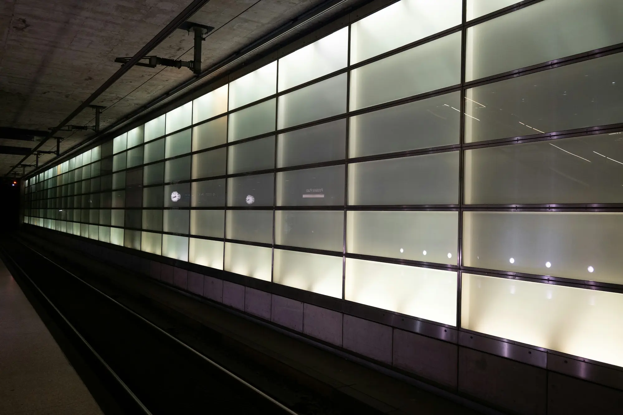 Illuminated wall panels along a station platform